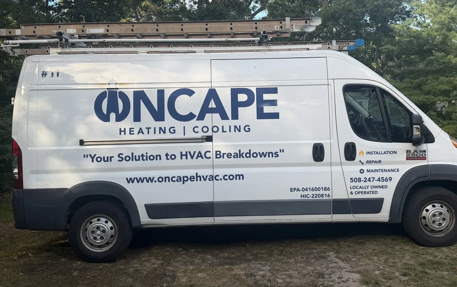 OnCape Heating and Cooling service van with the lighthouse logo, phone number, and ladders on its roof rack.